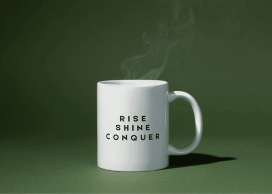 White ceramic mug with bold black text "Rise Shine Conquer" – motivational coffee mug from Livforia for morning inspiration